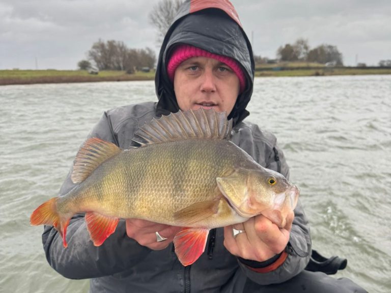Visgids Dutch Fishing Experience Een visser en een jongen tonen trots een grote snoek op een boot.